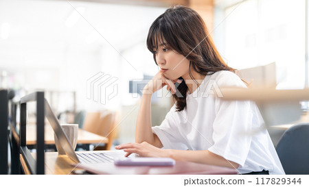 A woman thinking while using a computer 117829344