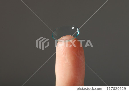 Close-up of a clear contact lens on a fingertip 117829629