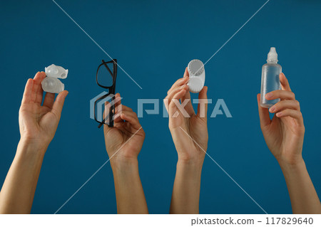 Glasses and a container for contact lenses in hands Glasses and a container for contact lenses in hands 117829640