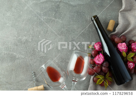 A bottle of wine with flowers and fruits, on a gray background. A bottle of wine with flowers and fruits, on a gray background. 117829658