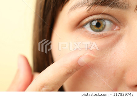 Installation of a contact lens in the eye close-up 117829742