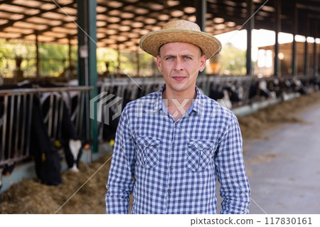 Cow farm owner posing in barn 117830161