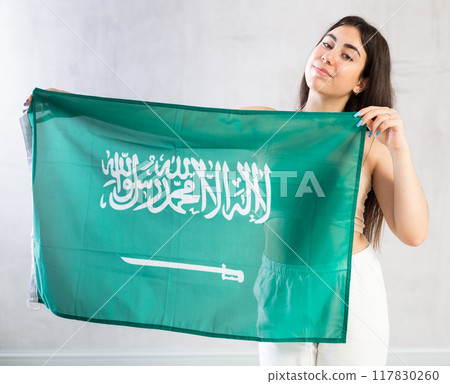 Young woman with flag of Saudi Arabia posing in studio Young woman with flag of Saudi Arabia posing in studio 117830260