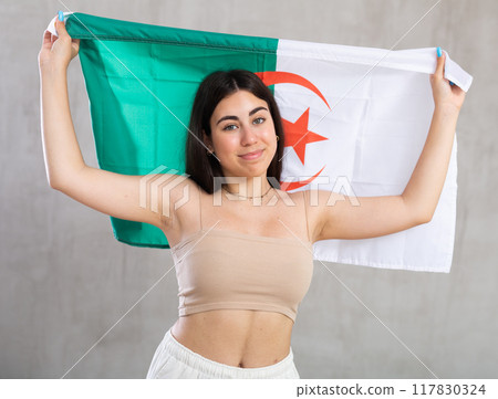 Young woman with flag of Algeria posing in studio Young woman with flag of Algeria posing in studio 117830324