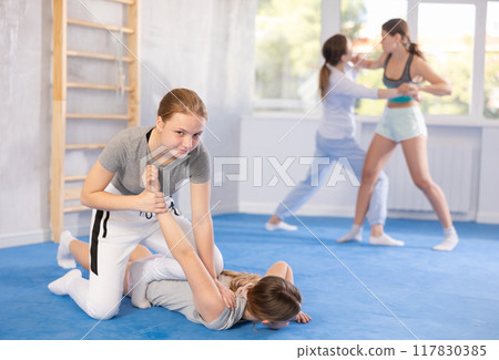 Females practicing self defence moves 117830385