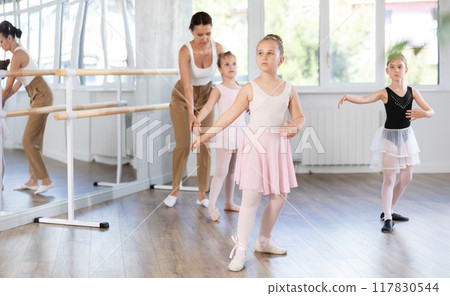 Girls in ballet class perform Batman with correction of female mentor Girls in ballet class perform Batman with correction of female mentor 117830544