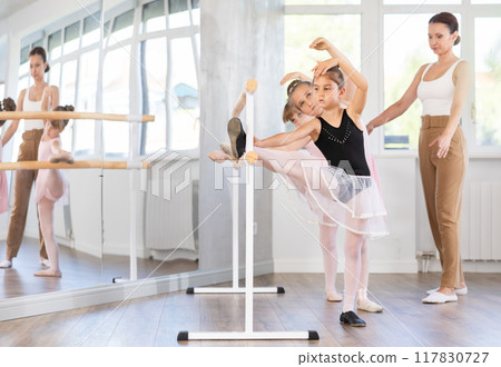 Little ballerinas together with choreography teacher in grand batman pose learn to dance ballet 117830727