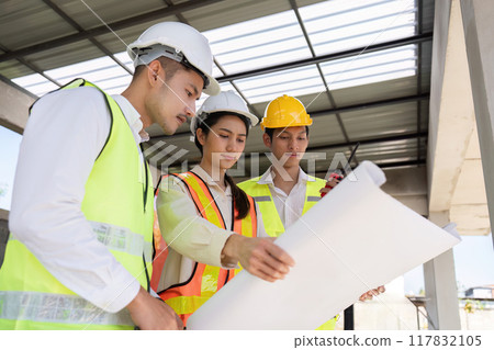 Engineers Analyzing Blueprints Together on Construction Site. Teamwork and Design 117832105