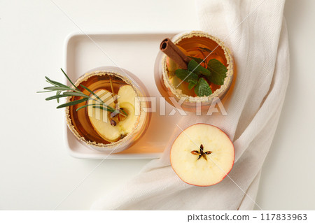 Glasses with apple cider and slices of apples on white background, top view 117833963