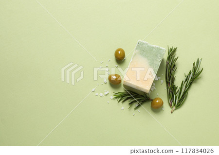 Soap with ingredients olives and rosemary, on a green background. Soap with ingredients olives and rosemary, on a green background. 117834026