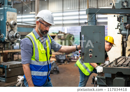 Industrial man engineer wear uniform and helmet checking system machine at factory. 117834418