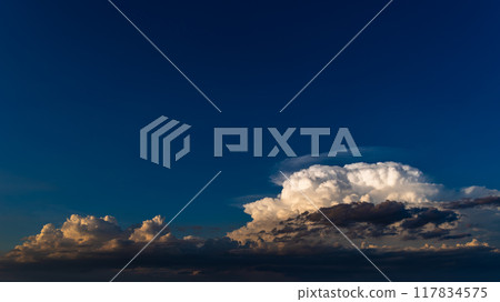 White cumulonimbus clouds in the blue sky of a summer evening a-2 High saturation contrast 117834575