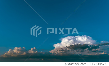 White cumulonimbus clouds in the blue sky of a summer evening a-3 light color 117834576