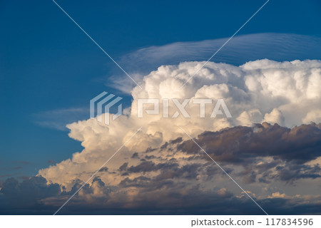 White cumulonimbus clouds in the blue sky of a summer evening c-1 117834596