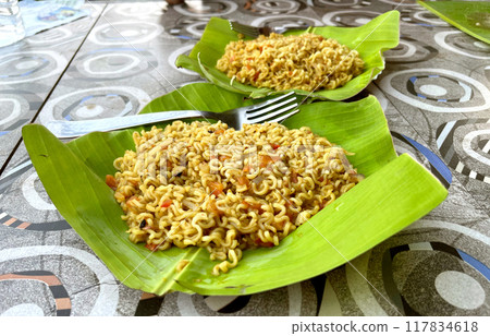 Beautiful view of Fried Maggi noodles on banana leaf in the mountains Beautiful view of Fried Maggi noodles on banana leaf in the mountains 117834618
