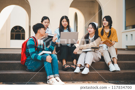 group of students young university students consulting doing homework, cooperating research plan Discuss concepts and strategies. Prepare presentations on laptops and tablet computers. 117834700