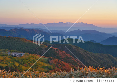 The Utsukushigahara Plateau shining in the morning sun and the Venus Belt spreading across the sky with the Togakushi mountain range in the distance 117835433