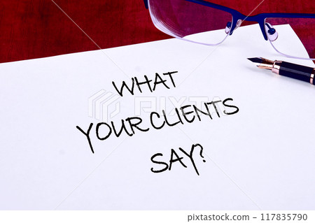 Business, feedback concept. Text WHAT OUR CLIENTS SAY on a blank sheet there is an inscription with a fountain pen Business, feedback concept. Text WHAT OUR CLIENTS SAY on a blank sheet there is an inscription with a fountain pen 117835790