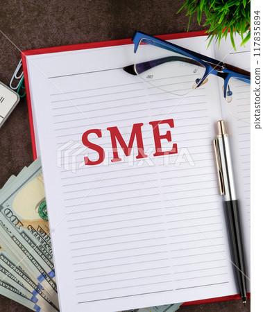 Word SME. Small and medium-sized enterprises - commercial enterprises. The SME symbol in a notebook, a vertical photo 117835894