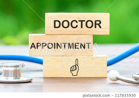Conceptual patient safety symbol. Copy space. DOCTOR APPOINTMENT words written on wooden blocks against a background of blurred green plants Conceptual patient safety symbol. Copy space. DOCTOR APPOINTMENT words written on wooden blocks against a background of blurred green plants 117835930