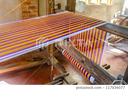 Cotton weaving on a wooden handloom Cotton weaving on a wooden handloom 117836077