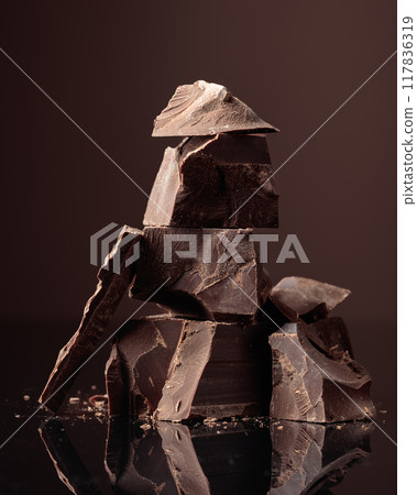 Pieces of bitter chocolate on a dark background. 117836319