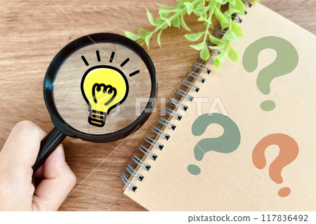 A notebook, a question mark, a light bulb and a magnifying glass 117836492