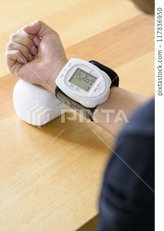 Man measuring blood pressure at home Man measuring blood pressure at home 117836950