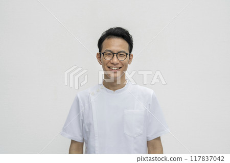 圖為一名30多歲的醫護人員身穿白大褂對著鏡頭微笑 117837042