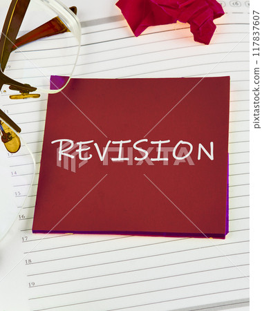 REVISION written on a red sticker on a white background, vertical photo, image 117837607
