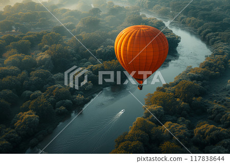 Hot orange air balloon is flying over a river. Aerial view 117838644