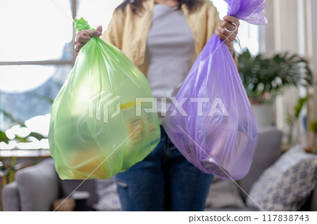 woman is holding bag for sorting garbage.  Trash can for Waste sorting in home. 117838743