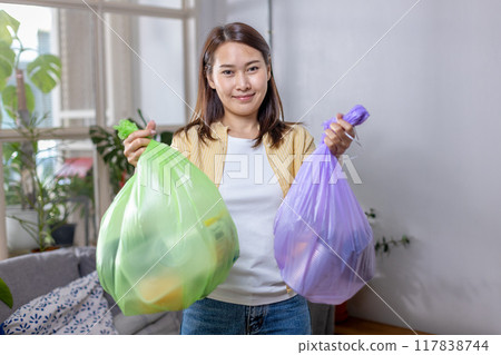 woman is holding bag for sorting garbage. Trash can for Waste sorting in home. woman is holding bag for sorting garbage. Trash can for Waste sorting in home. 117838744