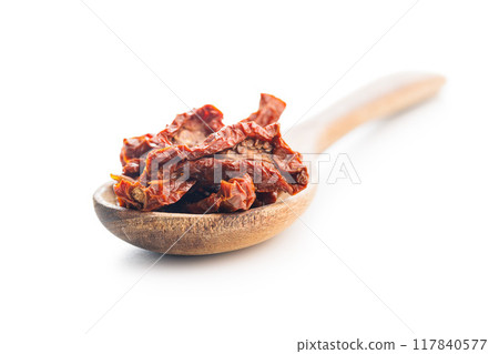 Sun dried red tomatoes on wooden spoon isolated on white background. Sun dried red tomatoes on wooden spoon isolated on white background. 117840577