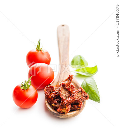 Sun dried red tomatoes on wooden spoon isolated on white background. 117840579