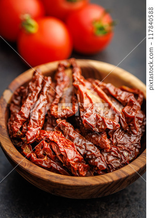 Sun dried red tomatoes in bowl on black table. Sun dried red tomatoes in bowl on black table. 117840588