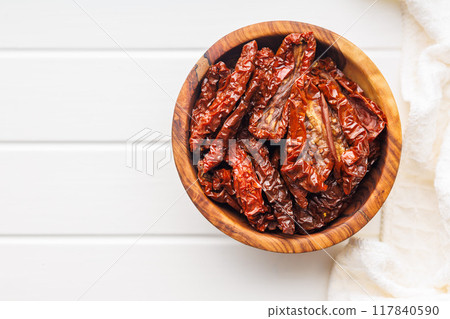 Sun dried red tomatoes in bowl on white table. 117840590