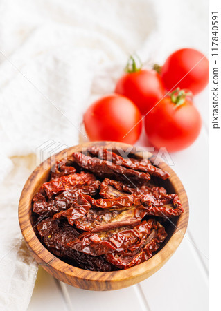Sun dried red tomatoes in bowl on white table. Sun dried red tomatoes in bowl on white table. 117840591