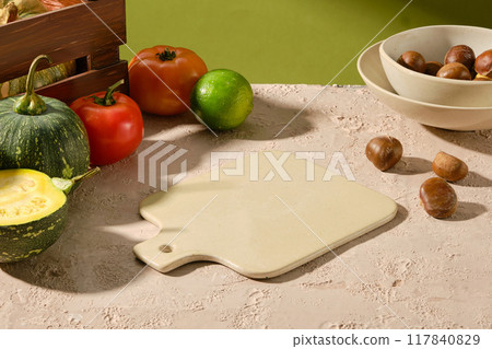 Template photo for advertising of vegetarian or dietary food, blank cutting board displayed in center, surrounded with fresh vegetable in fall season like pumpkin, chestnut and tomato Template photo for advertising of vegetarian or dietary food, blank cutting board displayed in center, surrounded with fresh vegetable in fall season like pumpkin, chestnut and tomato 117840829