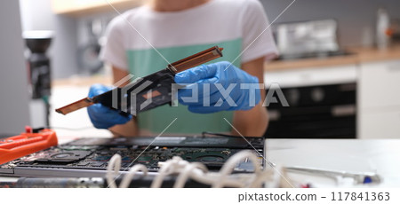 Hands in blue gloves hold a PC microcircuit 117841363