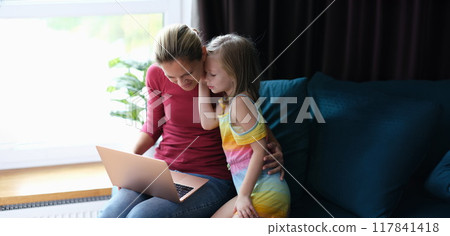 Little girl in the room talking to her mother with a laptop Little girl in the room talking to her mother with a laptop 117841418