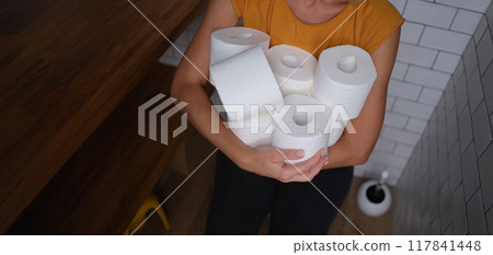 Woman in the wc holds many rolls of toilet paper 117841448