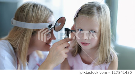 Cute little girl lets the doctor check ear, close-up Cute little girl lets the doctor check ear, close-up 117841480