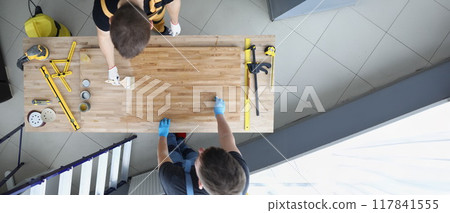 Carpenters apply varnish to a wooden surface, close-up 117841555