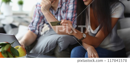 A married couple at home pays for purchases online A married couple at home pays for purchases online 117841578