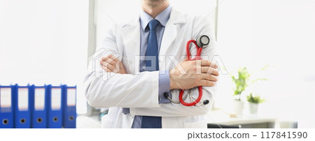 Male doctor in a white coat with a stethoscope in his hands 117841590