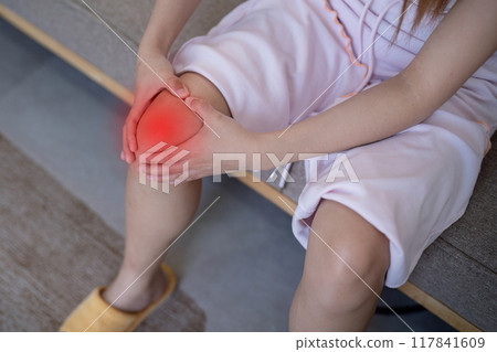 Woman Massaging Sore Knee at Home. Knee Pain Management 117841609