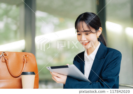 Woman using a tablet on a cafe terrace Woman using a tablet on a cafe terrace 117842020