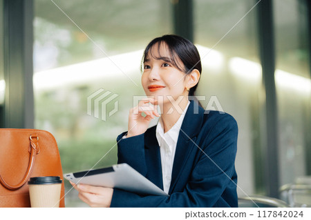 一位女士在咖啡館的露臺上使用平板電腦 117842024