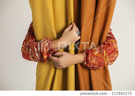 hands of creator, carefully holding fabrics, represent artistry involved in textile design, Autumn Elegance 117842273